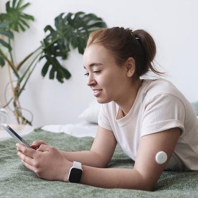 Girl on laying on her bed, typing on her phone